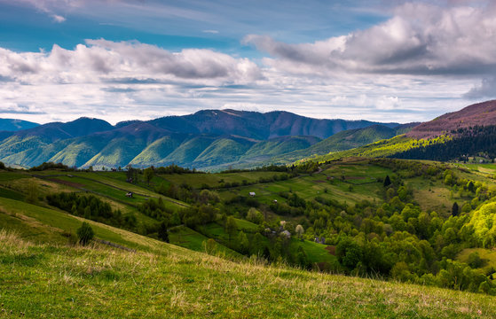 beautiful mountainous countryside in springtime. village outskirts with rural fields on rolling hills.