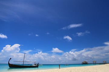a panorama of a tropical beach and a girl in the distance comes out of the azure water. bright sunny day