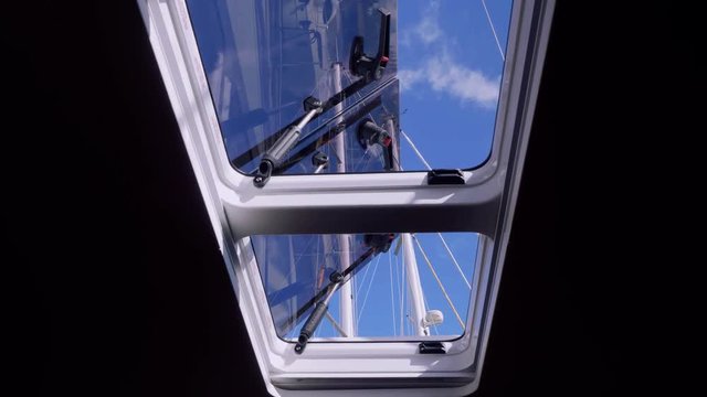 View of tackle and mast of yacht through window of yacht cabin
