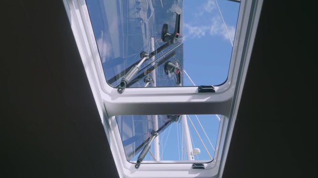 View of tackle and mast of yacht through window of yacht cabin
