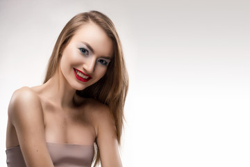 Portrait of the beautiful smiling blonde girl with red lips and red manicure.