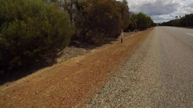 Fahrstrecke mit einem PKW auf einem Highway in West-Australien mit Kamerablickwinkel auf den linken Straßenrand	