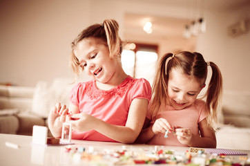 Obraz na płótnie Canvas Girls playing at home with Bricks.