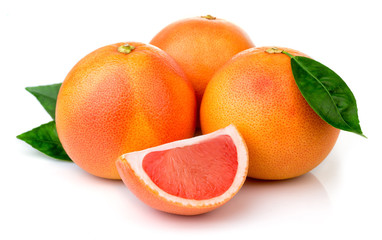 Pink grapefruits with green leaves isolated on white background