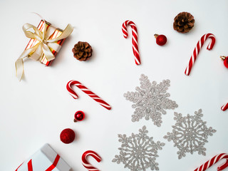 Joyful christmas background. Beautiful present boxes, traditional candy cane lollipops, snowflakes, Santa hat. Preparing for winter holidays concept, top view, copy space