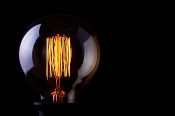 classic Edison light bulb on black background