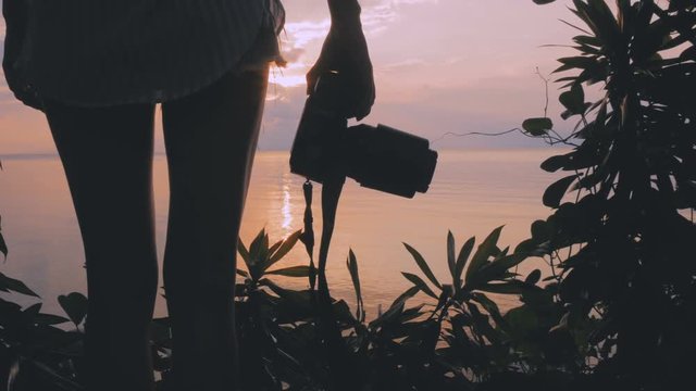 girl photographing at sunset with DSLR camera
