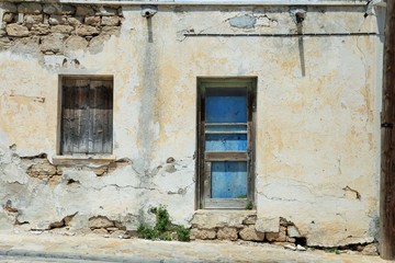 the wall of a ruined Cyprus house with a blue door