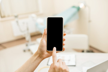 Mockup image of a smart phone on the ginecological office background