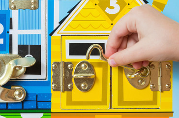 A game with locks. The child opens the locks. Busy-board for For children. Children's educational toys.