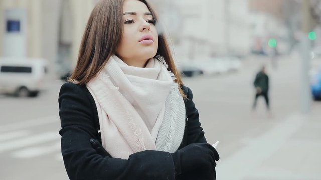 Woman smoking electronic sigarette in frost winter city