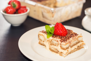 Homemade tiramisu cake decorated with strawberries Italian cuisine, Selective focus