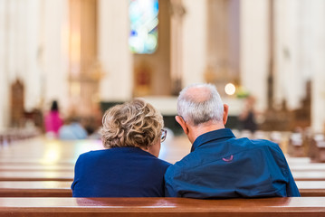 Back view of an elderly couple in the church, Madrid, Spain. Copy space for text.