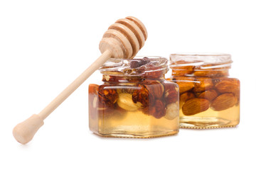 A honey jar with a spoon for honey nuts