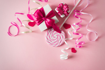 Valentines and birthday card with lollipop or candy and gift on pink background