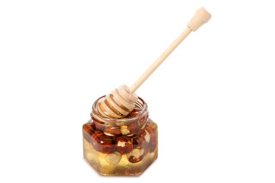A honey jar with a spoon for honey nuts