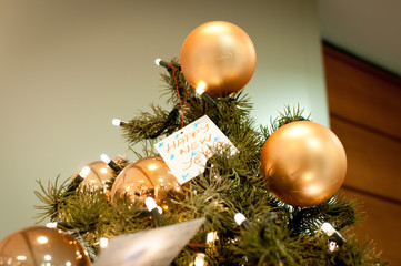 Happy new year text card  on tree with Christmas decoration, gold Christmas balls