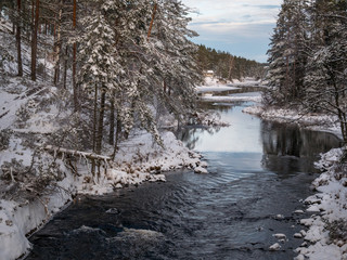 The cold snow winter river in evening light