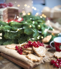 cake with berries and biscuits, gifts, near a Christmas tree on a village table