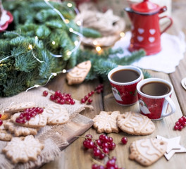 two small cups of coffee and a coffee pot, berries and cookies, gifts, near a Christmas tree on a village table