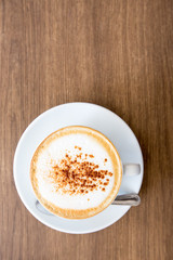 hot cappuccino on wooden table 