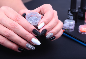 Black, white Nail art manicure. Holiday style bright Manicure with sparkles. Bottle of Nail Polish. Beauty hands. Stylish Nails, Nail Polish
