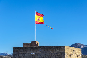 Torn Spanish flag waving on the wind