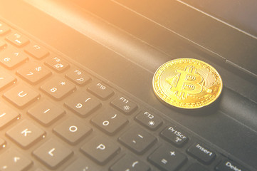 Bitcoin coin placed on modern black notebook . Close-Up photo Bitcoin , exchange virtual value, crypto digital money . Background Live Stock trading through internet .Selling big amounts, real estate.
