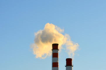 smoke from a chimney against a blue sky, pollution, poisoning the environment, industrial landscape