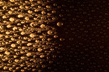 Texture water drops on a black background with light