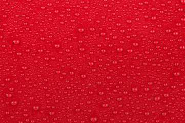 Texture of water drops on a red background