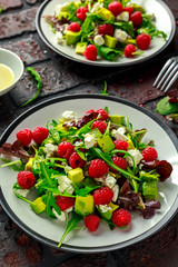 Fresh Tasty Raspberry salad with avocado, green vegetables, nuts, feta cheese, olive oil and herbs. healthy food.