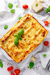Homemade lasagna with minced beef bolognese and bechamel sauce topped wild basil, parmesan cheese