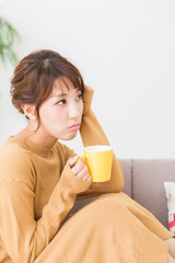 部屋で飲み物を飲む女性