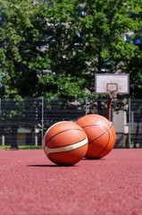 Two basketball balls on the ground of public court