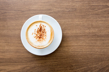 hot cappuccino on wooden table 