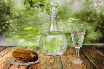 Still life with a decanter and a glass of vodka with pickles