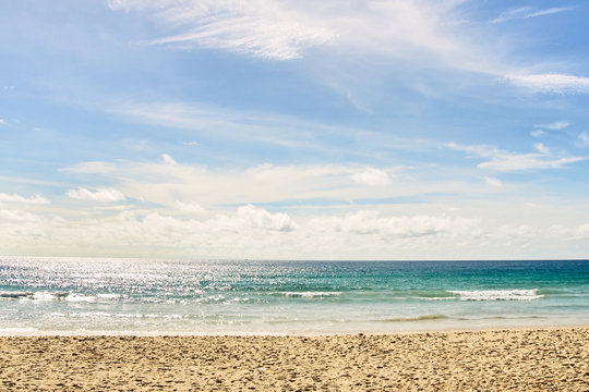Fototapeta Warm blue sea. White clouds. Light Sand