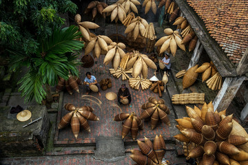 Top view of Group of Old Vietnamese female craftsman making the traditional bamboo fish trap or weave at the old traditional house in Thu sy trade village, Hung Yen,Vietnam, traditional artist concept