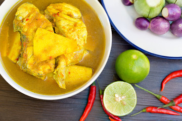 Yellow curry with Snapper fish and coconut shoot in white bow on wooden table Thai food  delicious