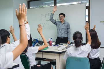 Asian teacher Giving Lesson over the the physics formular on white board in science laboratory...