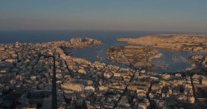 MALTA – AUGUST 2016 : Aerial shot over Sliema cityscape during a beautiful sunset with Valletta harbor and Manoel Island in view