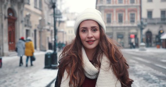 Close up happy young woman with long hair walks around the city portrait charming smiling christmas fun girl holiday happiness casual beauty celebration attractive face snow winter slow motion