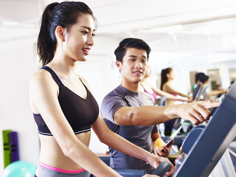 young asian woman exercising on treadmill