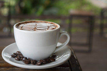 White coffee mug on patterned old wooden floor.