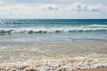 Sea waves. Blue water. White clouds