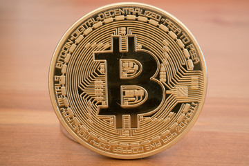 Real golden bitcoin on wood