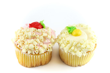 fresh baked muffins with colorful cream on top isolated on white background