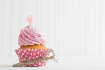 pink cupcake on white wooden background