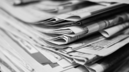 Pile of newspapers, stack and folded. Selective focus, blurred background texture